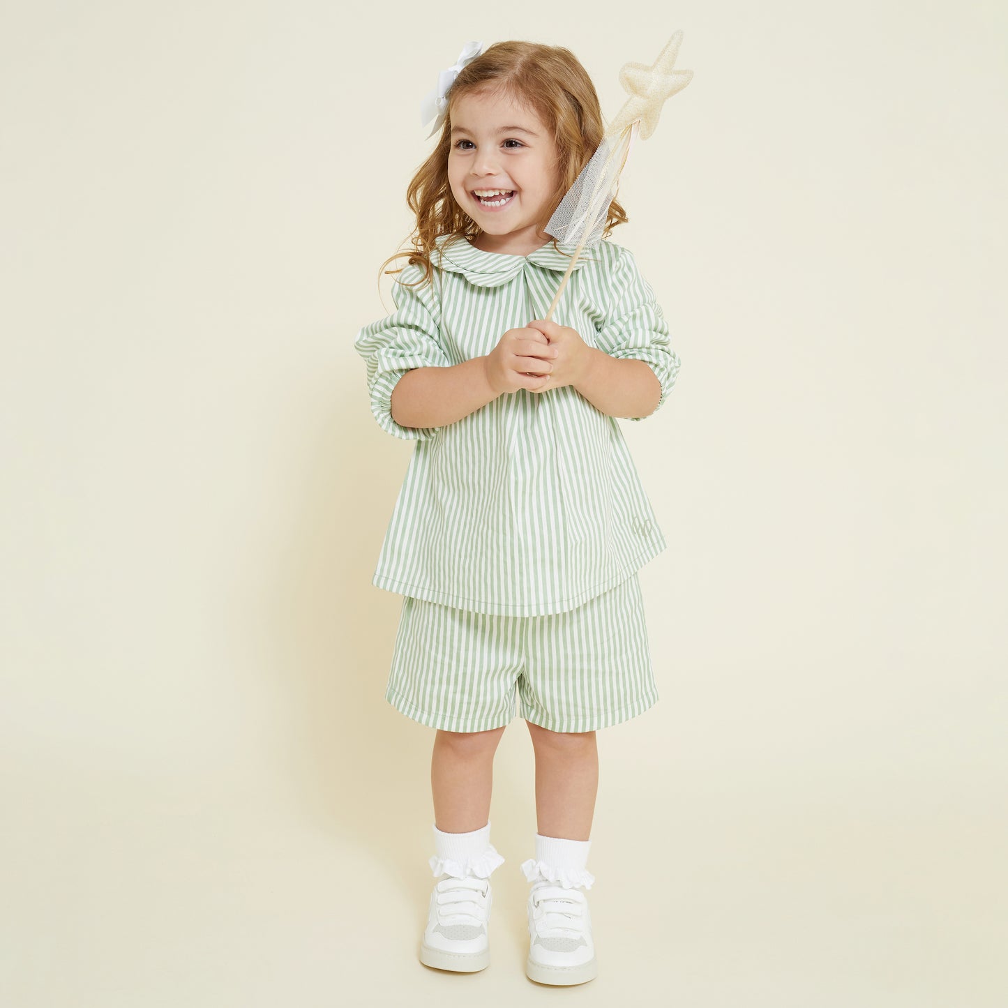 4 year old girl wearing matching set of casual short and collared scallop shirt in sage and white stripe