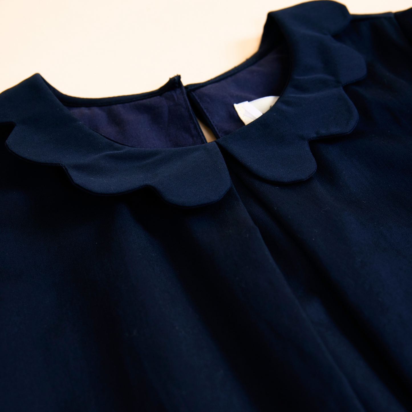 Close up of navy scalloped collar detail on smock dress neckline