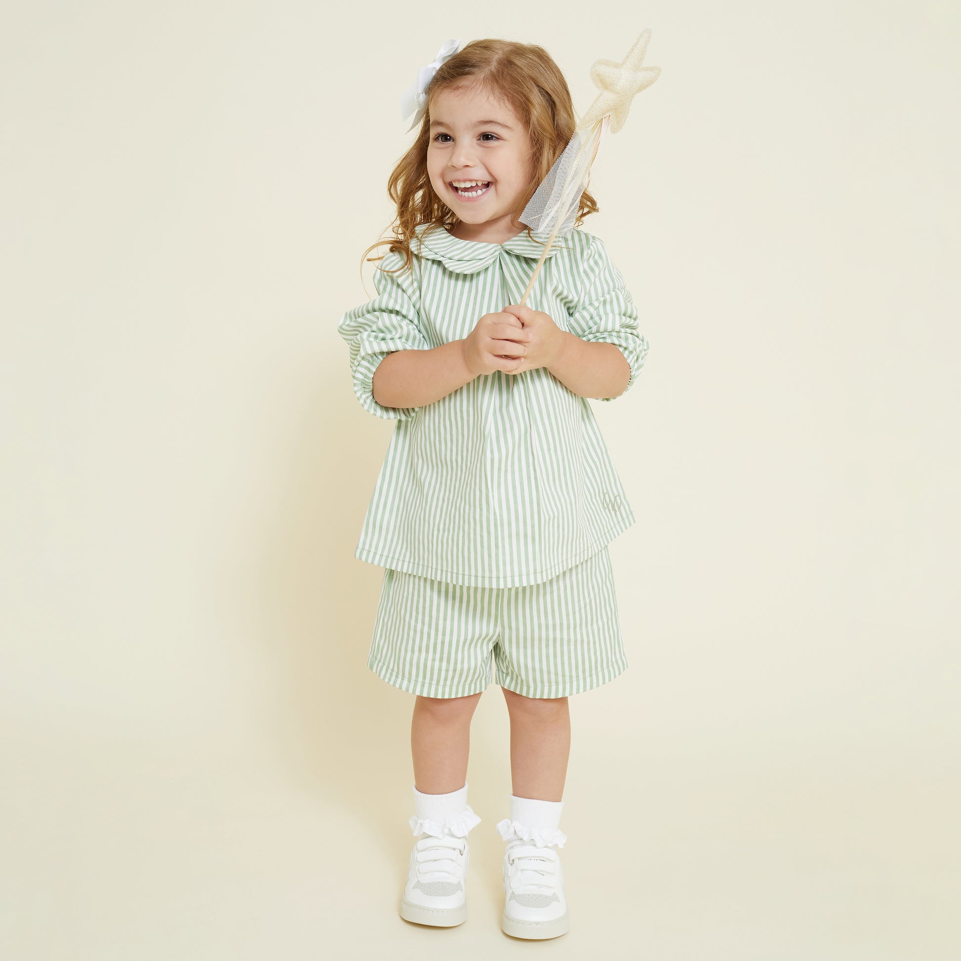 4 year old girl wearing matching set of casual short and collared scallop shirt in sage and white stripe
