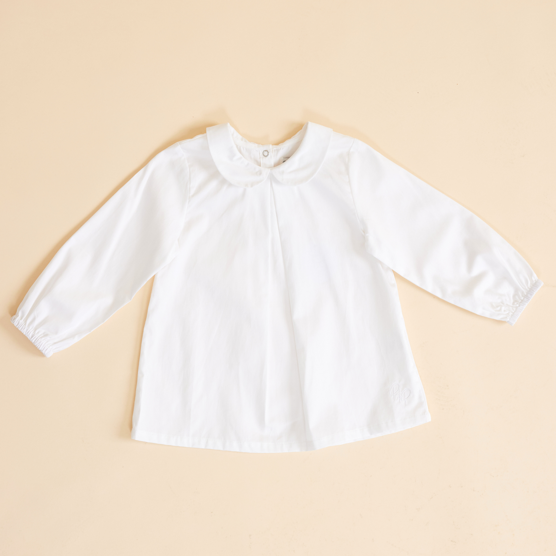 Flat lay of collared shirt showing Peter Pan Collar in milk white