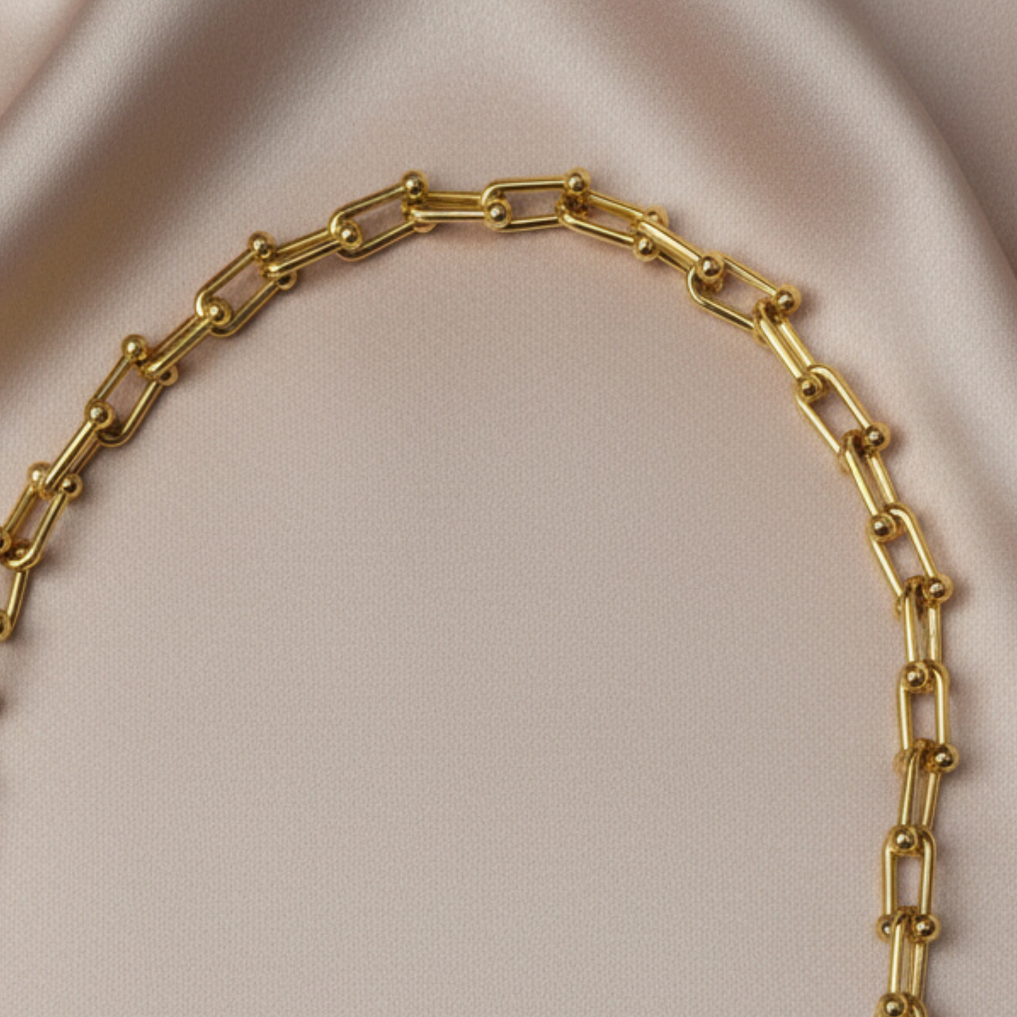 A close up photo of an 18k gold plated modern geometric chain necklace