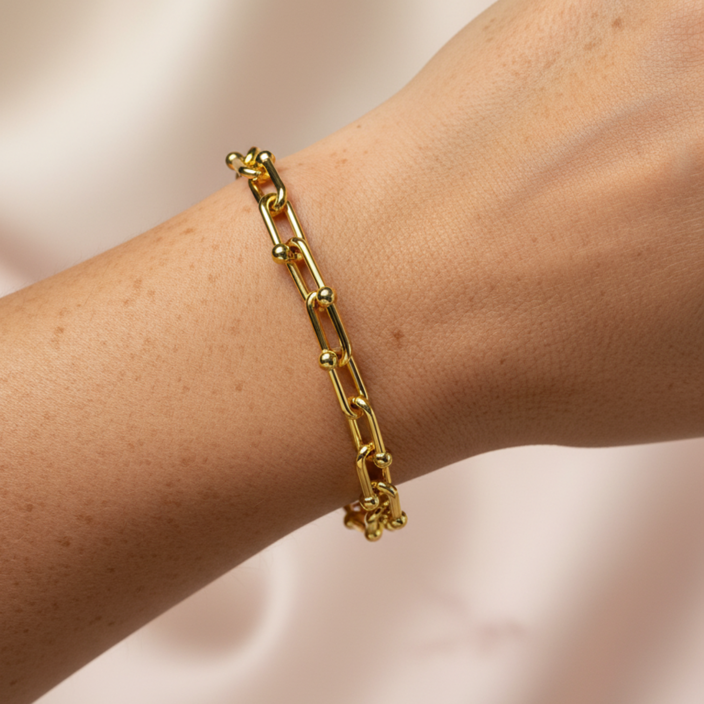 A detailed photo of 18k gold plated chunky bracelet on a wearer's wrist