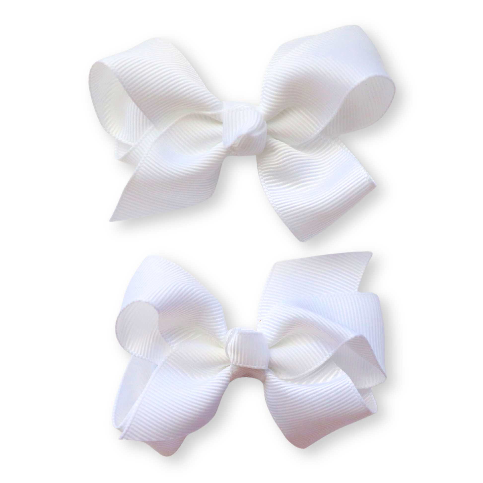 Two white hair bows on a light beige background