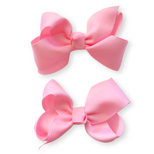 Two pink hair bows on a white background
